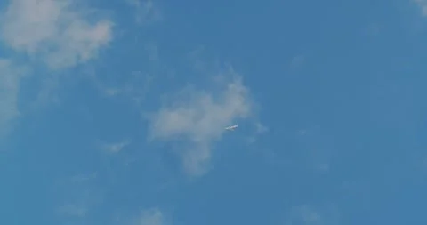 Flying airplane in the cloudy blue sky.The plane flies against the blue sky. Stock Footage 258849518