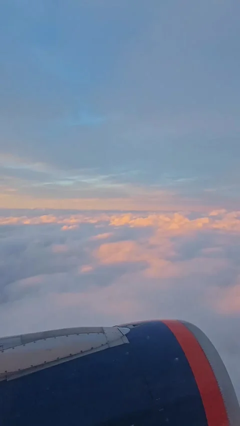 Flying in an airplane. The wing of an airplane flying above the clouds Video stock 340808173