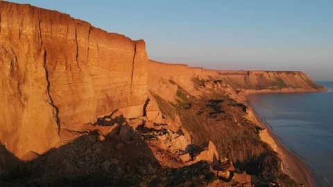 Flying along the coastline red cliffs of the sea at red sunset. Stock-Footage 111769313