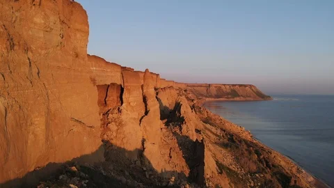 Flying along the coastline red cliffs of the sea at red sunset. Stock Footage 111951550
