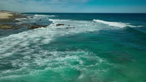 Flying along curling waves rolling into the beach Stock Footage 236742167