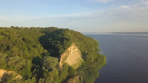 Flying along a high hill by the river Stock Footage 112763981