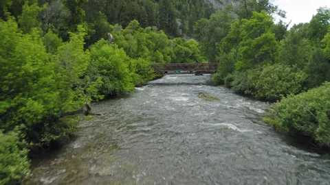 Flying along overflowing Provo River, bridges during excess snow melt conditions Stock Footage 248174648