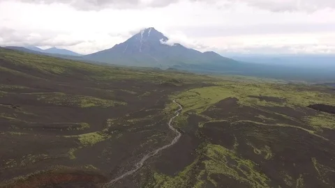 Flying along the river to the mountains. The span of the volcano Stock Footage 72683270