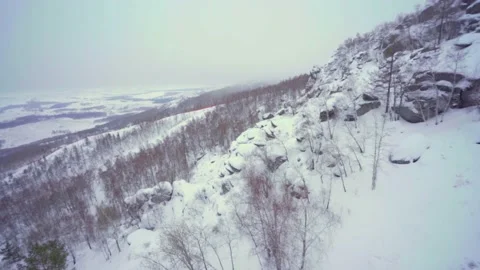 Flying along a snow-covered mountain Stock Footage 148377002