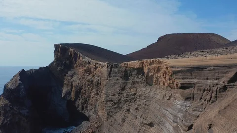 Flying along steep cliff. Volcanic rocks of Faial island Stock Footage 117305260