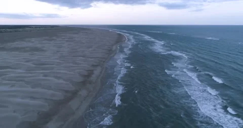 Flying along tropical beach over storm debris and water waves Video stock 201058939