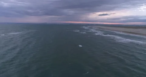 Flying along tropical beach over storm debris and water waves Stock Footage 201063072