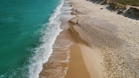 Flying along turquoise waves towards walking family with kids on sandy beach Video stock 86519002