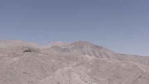 Flying up and along side mountain on the outskirts of desert city Stock Footage 245510601