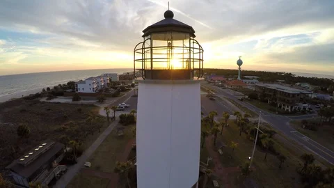 Flying and ascending behind a lighthouse with sunset in distance and flying over Stock Footage 90560865
