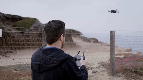 Flying and Landing a Drone from Behind Stock Footage 101446011