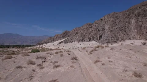 Flying up and over small mountain in the desert Stock Footage 246257217