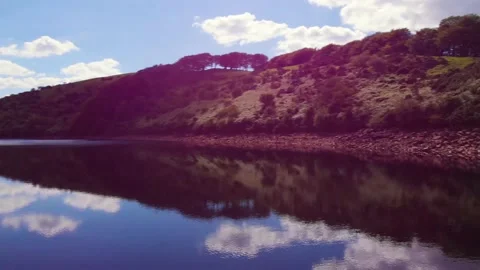 Flying and panning over cloud reflections on Meldon resevoir, Devon, UK 動画素材 135519628