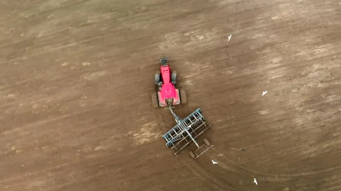 Flying around the axis over a modern tractor with a disc harrow. A farmer Stock Footage 131373184
