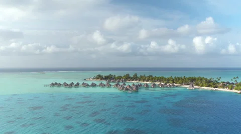 Flying around beautiful high class overwater villas at hotel resort Stock Footage 60590603