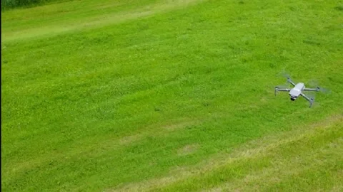 Flying around a drone and its remote pilots Stock Footage 156506699