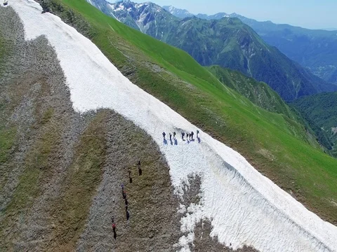 Flying around group of hikers tourists moving on mountain range Aerial 4k video Stock Footage 80314559