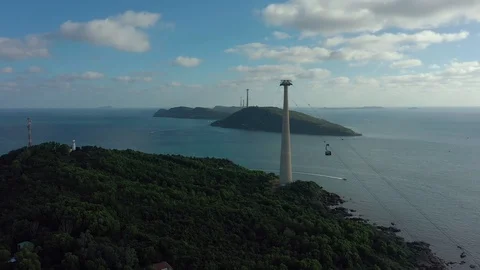 Flying around huge cable car in sunset connecting several islands in the ocean w Stock Footage 124367253