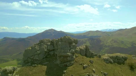 Flying around a large stone block with a man sitting on it. Pushkin Pass Armenia Video stock 254456386