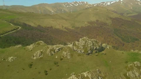 Flying around a large stone block with a man sitting on it. Pushkin Pass Armenia Stock Footage 254457186