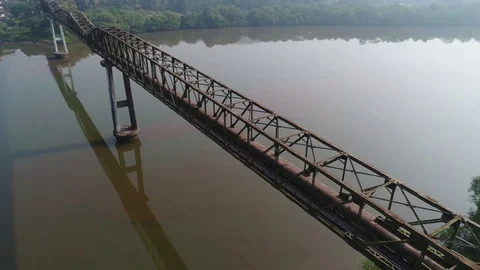 Flying around a long aqueduct over a muddy river. Aerial view. 動画素材 85454523