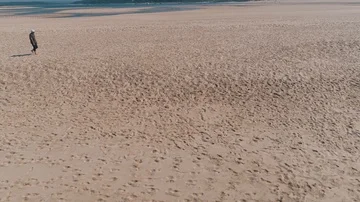 Flying Around Man Walking on Ocean Beach Stock Footage 85488274