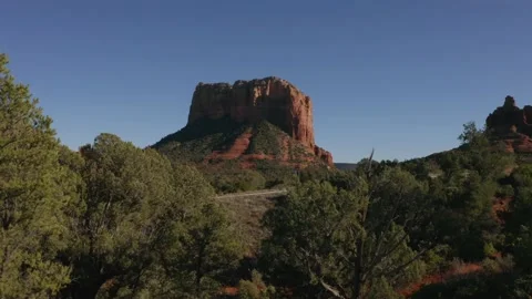 Flying around a pine tree and revealing Courthouse Butte and Bell Rock in the di Stock Footage 131329542