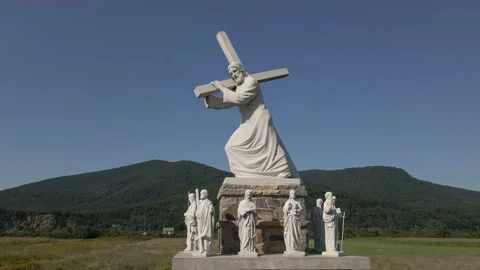 Flying around a statue of jesus christ who carries a cross on his shoulder Stock Footage 138299145