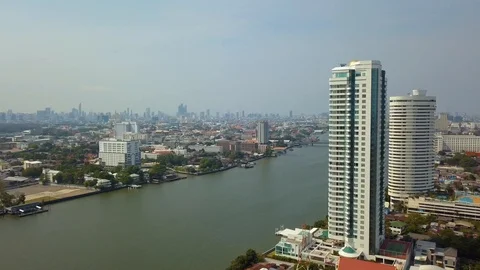 Flying around two big towers next to river with panoramic view of Bangkok Stock Footage 108538014