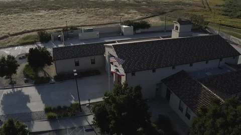 Flying around a US Fire Station in Orange County California with a US Flag Stock Footage 108781004