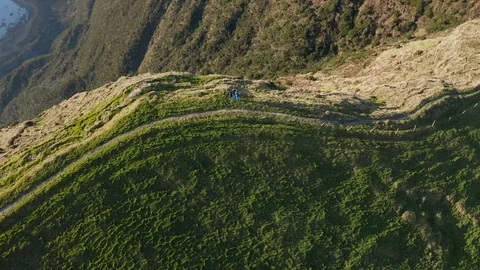 Flying away from caldrea edge. Pair of friends stays on the top of big volcano Видео 118016482