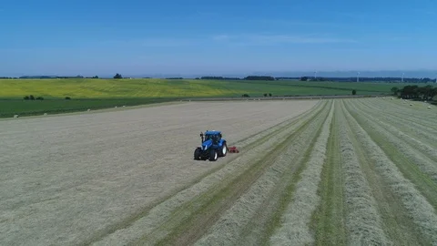 Flying away from farmer using tractor reveals farmland in rural Scotland Stock-Footage 99013027