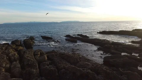 Flying away from ocean and over rocks Stock Footage 89019750