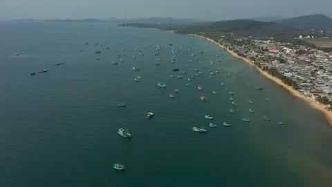 Flying back be drone hign above island and floating ships in harbour with view o Stock Footage 124214043