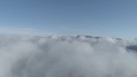 Flying back high over the clouds, blue sky into the misty clouds Stock Footage 147900686