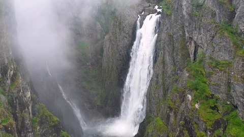 Flying back through clouds from the beautiful Voringsfossen Waterfall, Norway Stock Footage 114066568
