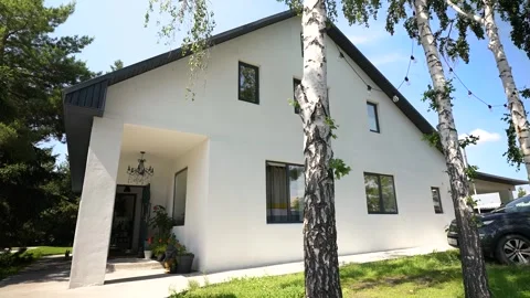 Flying back with a view of a white two-story country house in a daytime forest Stock Footage 278484367