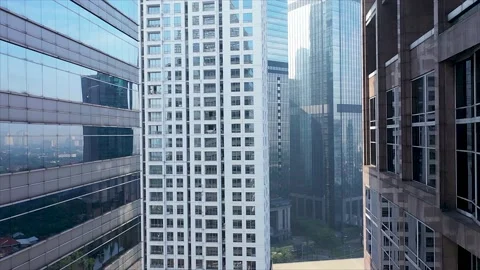 Flying backward between Glass skyscrapers in downtown area of a Modern city Stock Footage 211825329