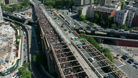 Flying backward view of black lives matter march walking onto Bkln Bridge Stock Footage 133099535
