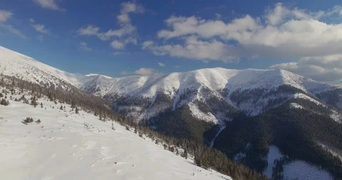 Flying backwards above top of the mountain in snow winter. Beautiful sunny day.  Stock Footage 85883243