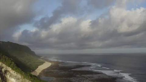 Flying backwards, aerial view of ocean, high cliffs and dramatic cloudscape Stock Footage 115996673
