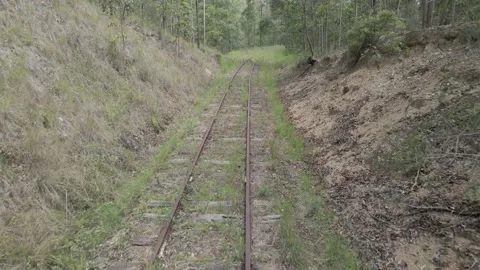 Flying Backwards along train tracks that disappear into grass Video stock 148608145