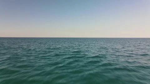 Flying backwards over calm ocean - Fast 4K aerial with cinematic motion blur Stock Footage 137983143