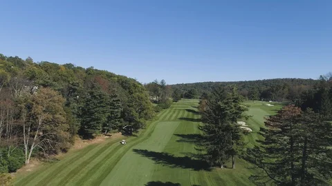 Flying Backwards Over Golf Course with Golf Car Driving towards Stock Footage 91899436