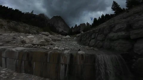 Flying backwards over a rocky stream in the dolomites mountains Vídeos de archivo 327027191