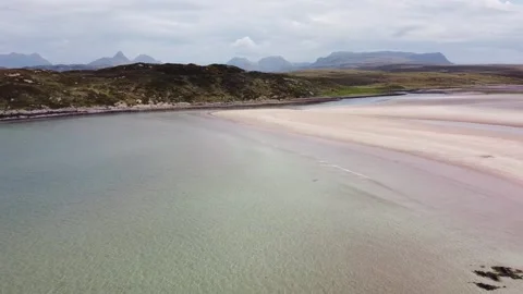 Flying backwards over Scottish beach to reveal rocky shore, calm day Stock Footage 159706573