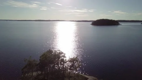 Flying backwards over small island at lake in evening Stock Footage 157007119