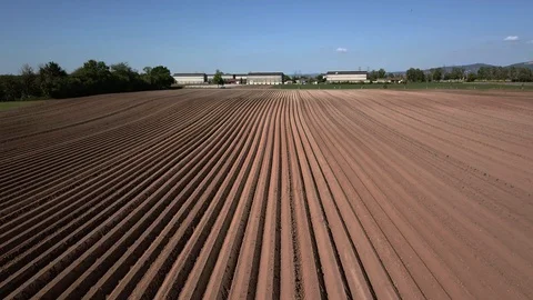 Flying backwards same height over agricultural fields with pattern soil Stockbeeldmateriaal 129357006