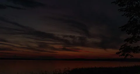 Flying backwards slowly over lake at sunrise with some lake grass and reeds Stock Footage 136975010